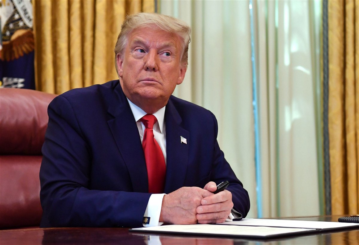 US President Donald Trump looks on before signing the pardon for Alice Johnson, in the Oval Office of the White House in Washington, DC, on August 28, 2020. - Trump granted Johnson, a criminal justice reform advocate and former federal prisoner, a full pardon after commuting her sentence in 2018. (Photo by NICHOLAS KAMM / AFP) (Photo by NICHOLAS KAMM/AFP via Getty Images)