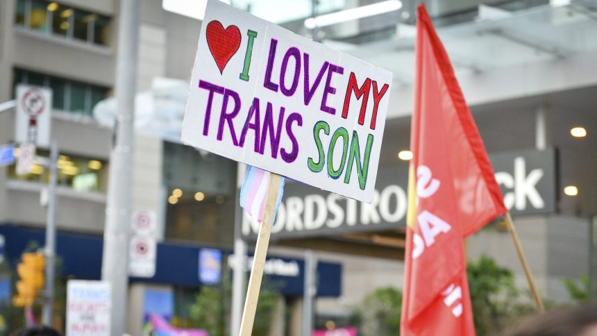 Protesters gather ahead of the Sydney Gay and Lesbian Mardi Gras parade next to a banner with the colors of the trans movement on March 6 in Australia.
