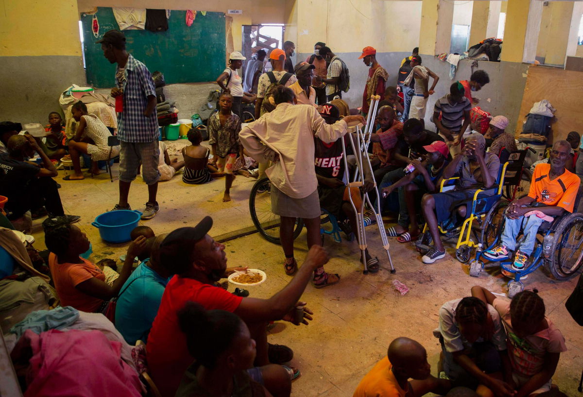 <i>Joseph Odelyn/AP</i><br/>A group of blind and disabled people eat at a refuge for displaced persons after armed gangs set their homes on fire in Port-au-Prince on June 24.