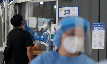 Lockdowns toughen in Seoul and Sydney as Delta variant Covid-19 outbreaks grow. A medical worker in a booth takes a nasal sample from a man during Covid-19 testing at its site in Seoul on Thursday.