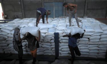 Ethiopian porters unload food aid bound for victims of war after a checkpoint leading to Tigray in Mai Tsebri town