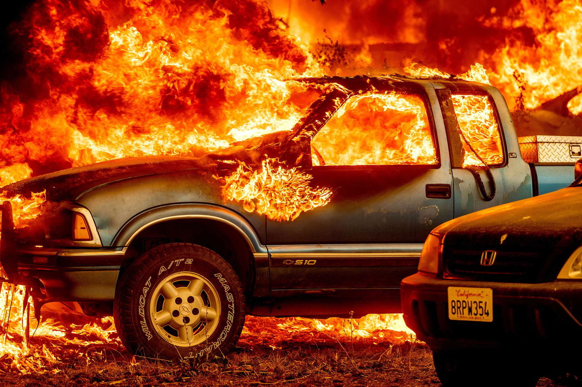 Flames from the Dixie Fire consume a pickup truck on Highway 89 south of Greenville on Thursday, Aug. 5, 2021, in Plumas County, Calif. (AP Photo/Noah Berger)