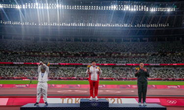 Raven Saunders performing her X gesture on the shot put medal podium.