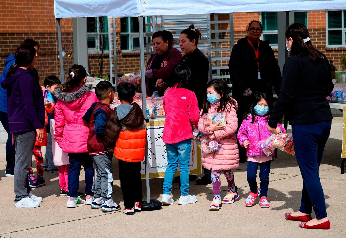 <i>Andrew Caballero-Reynolds/AFP/Getty Images</i><br/>Children pick up lunch at Kenmore Middle School in Arlington