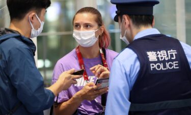 Belarusian athlete Kristina Timanovskaya talks with police at Haneda international airport in Tokyo on August 1.