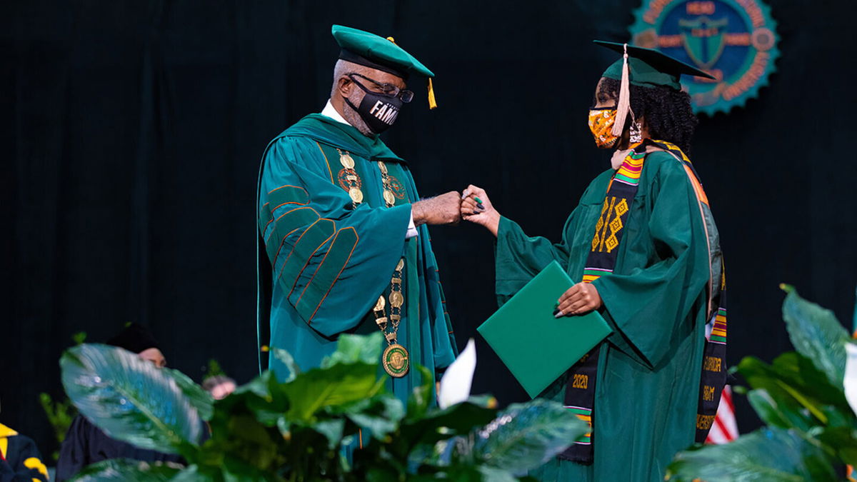 <i>Christian Whitaker/Florida A&M University</i><br/>FAMU President Larry Robinson greets a 2020 graduate during the July 31 ceremony.