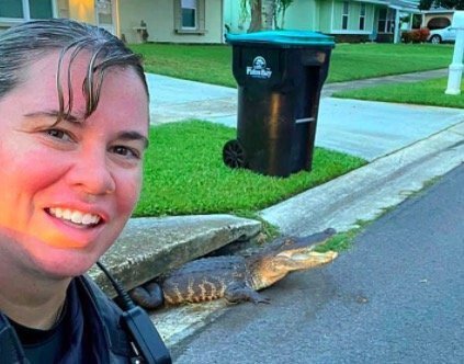 <i>Palm Bay Police/Facebook</i><br/>A Palm Bay police officer took a selfie with an alligator emerging from a storm drain.