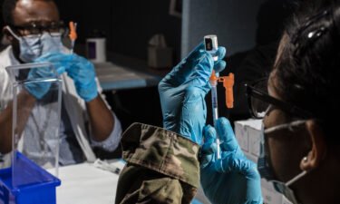 A member of the United States military prepares a dose of the Pfizer-BioNTech Covid-19 vaccine in Newark
