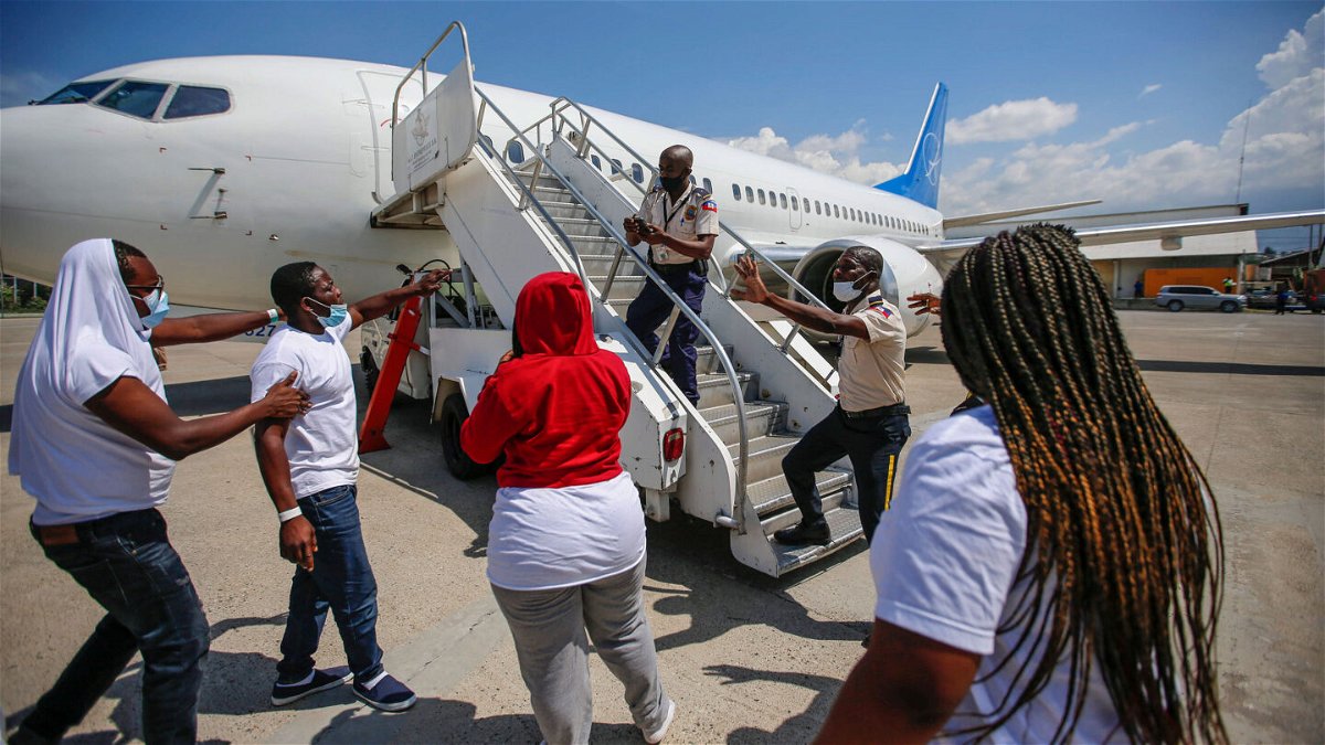 <i>Joseph Odelyn/AP</i><br/>Police officers try to block a deportee from boarding the same plane he and others were deported in.