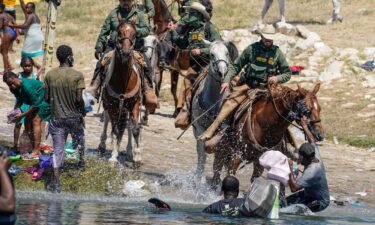 US Border Patrol agents on horseback try to stop Haitian migrants from entering an encampment on the banks of the Rio Grande near the Acuna Del Rio International Bridge in Del Rio
