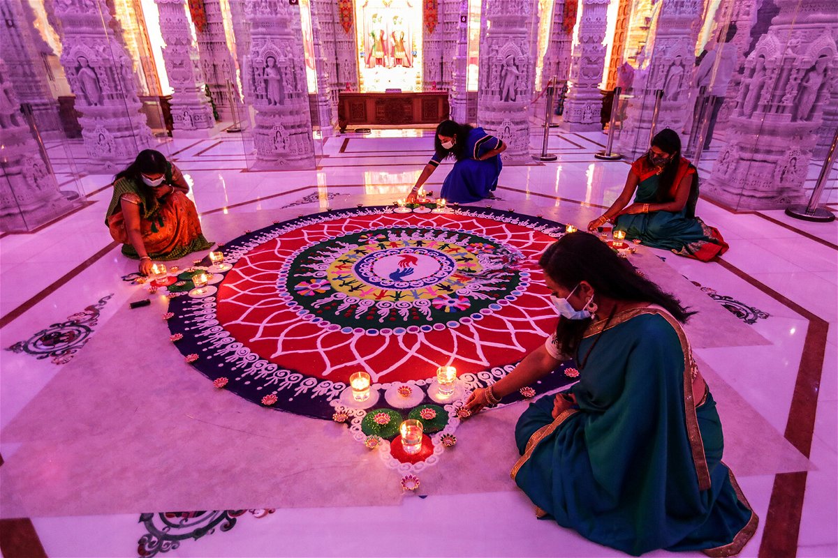 <i>Robert Gauthier/Los Angeles Times/Getty Images</i><br/>How Indian Americans are making Diwali their own. Women are seen tending to a rangoli during a Diwali celebration in Chino Hills