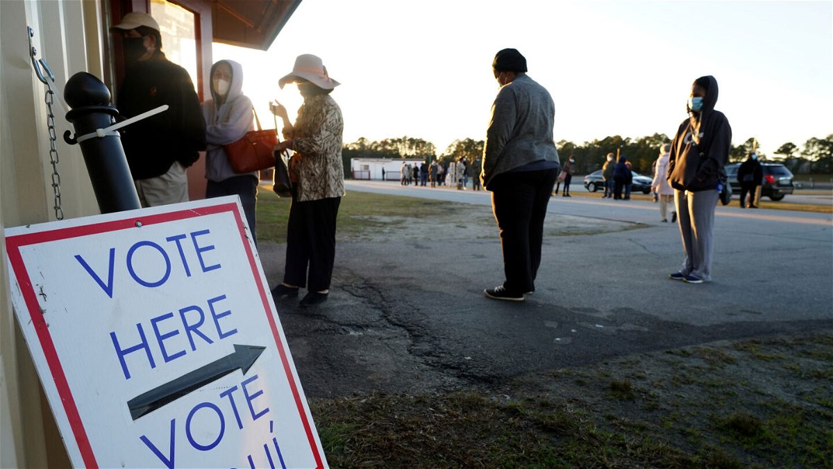 <i>TAMI CHAPPELL/AFP via Getty Images</i><br/>Voters stand in line to cast their ballots during the first day of early voting in the US Senate runoff at the Gwinnett Fairgrounds