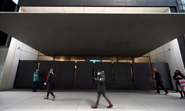 People walk past the entrance of The Museum of Modern Art (MoMa) which remains temporarily closed after two employees were stabbed the previous day