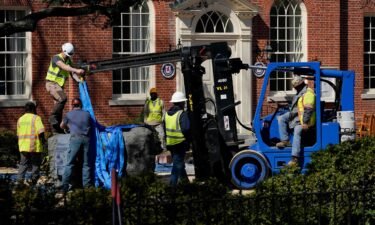 Workers removing the base of the Confederate statue on Monday.