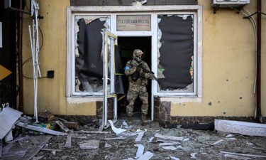 A Ukrainian serviceman exits a damaged building after shelling in Kyiv