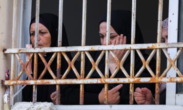 Mourners attend Amjad al-Fayed's funeral from a window in Jenin.