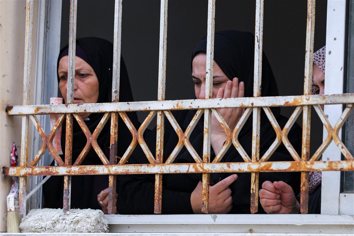 <i>Raneen Sawafta/Reuters</i><br/>Mourners attend Amjad al-Fayed's funeral from a window in Jenin.