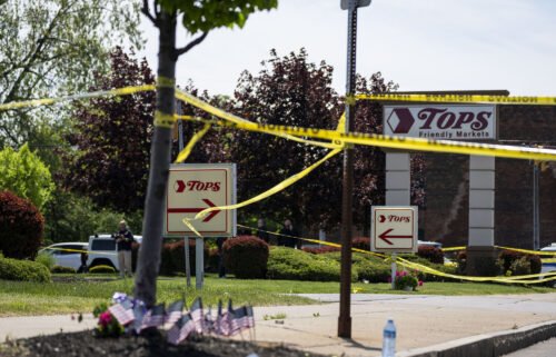 People gather outside the police tape at Tops Friendly Market at Jefferson Avenue and Riley Street on May 15