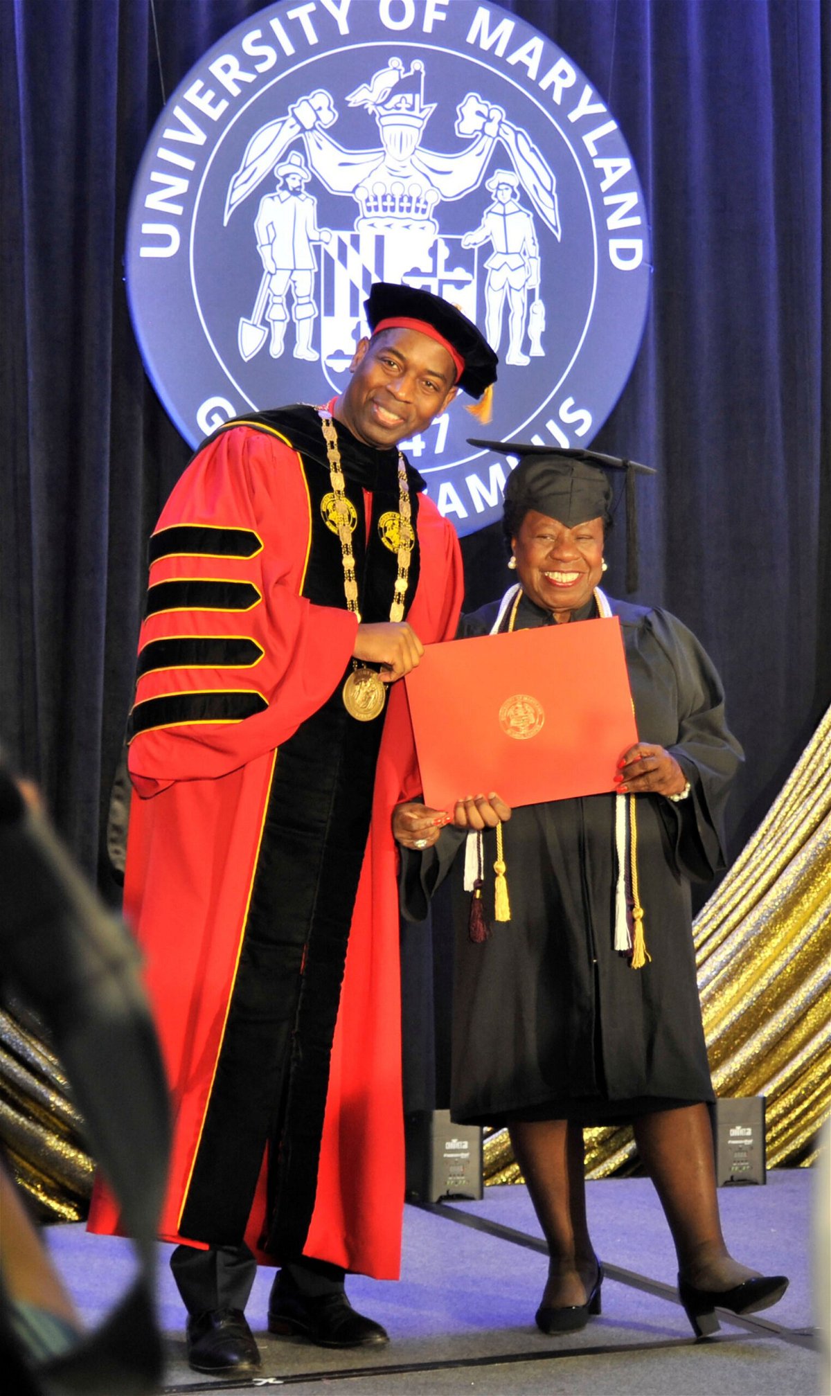 <i>Bob Ludwig/University of Maryland Gloal Campus</i><br/>Mae Beale receives her diploma during a University of Maryland Global Campus commencement ceremony from UMGC President Gregory Fowler.