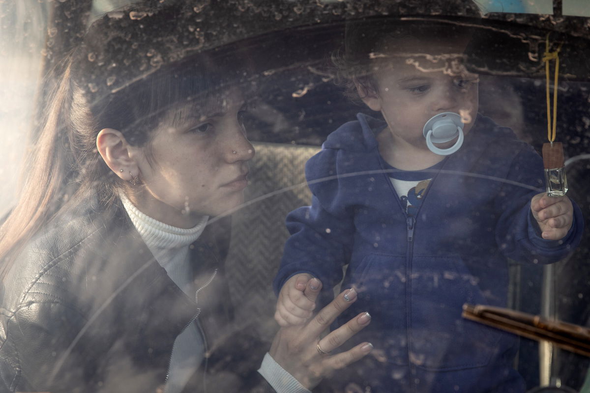 <i>Chris McGrath/Getty Images</i><br/>A woman and her child arrive at an evacuation point for people fleeing Mariupol