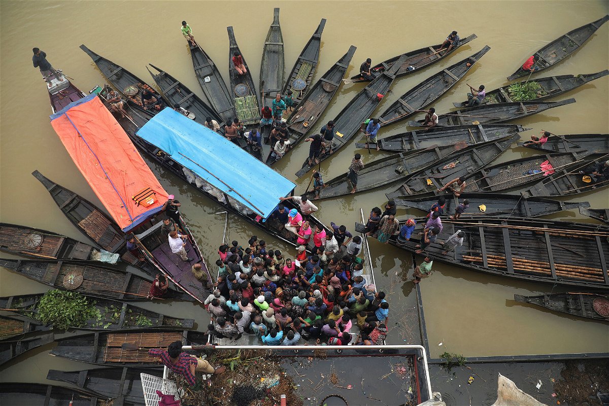 <i>Maruf Rahman/AFP/Getty Images</i><br/>People gather to collect food aid in a flooded area in Companiganj