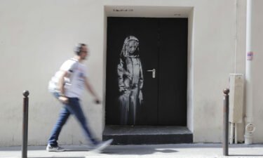 A man walks past a recent artwork by street artist Banksy in Paris in June 2018. Eight men were convicted on June 23 by the Paris Criminal Court for stealing Banksy artwork from the Bataclan concert hall in November 2015.