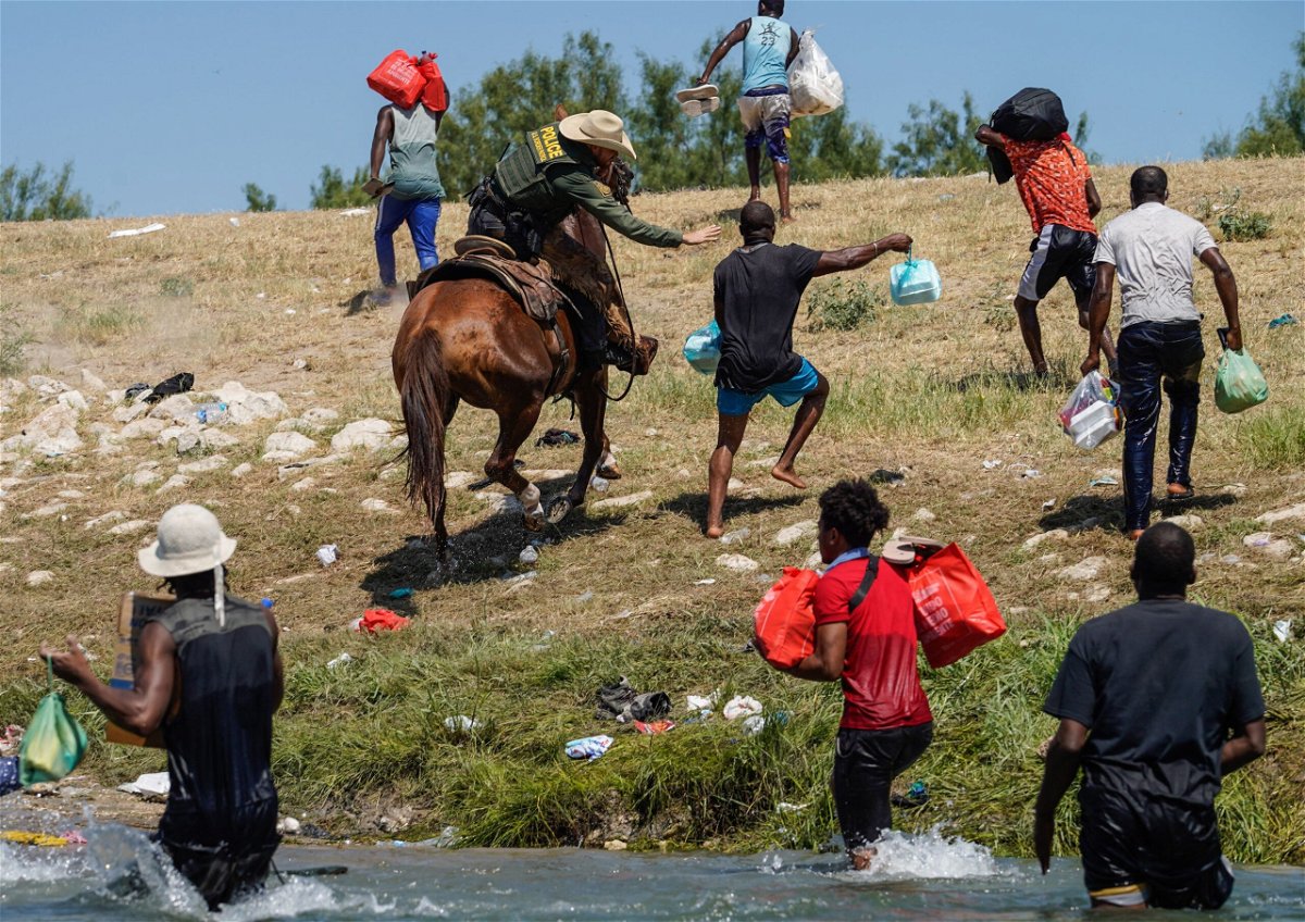 <i>Paul Ratje/AFP/Getty Images</i><br/>A United States Border Patrol agent on horseback tries to stop a Haitian migrant from entering an encampment on the banks of the Rio Grande near the Acuna Del Rio International Bridge in Del Rio