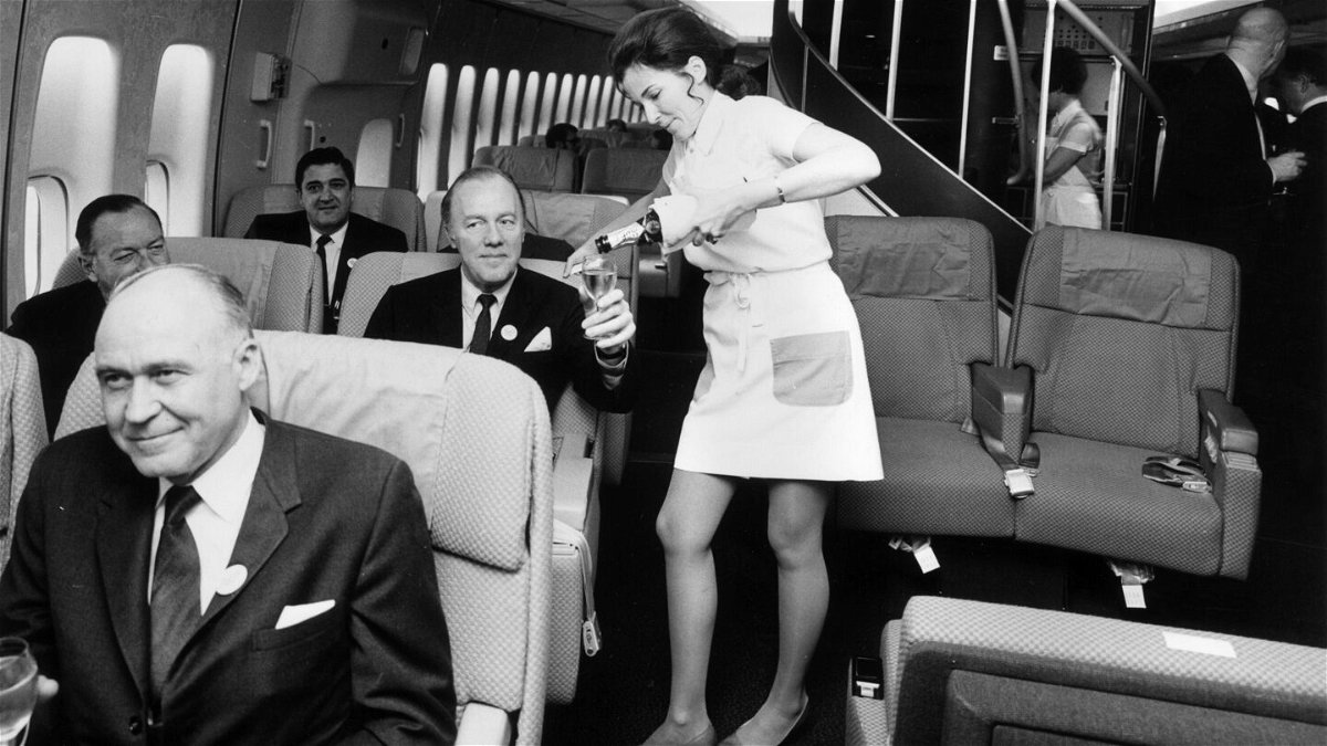 <i>Tim Graham/Getty Images</i><br/>A Pan Am flight attendant serves champagne in the first class cabin of a Boeing 747 jet.