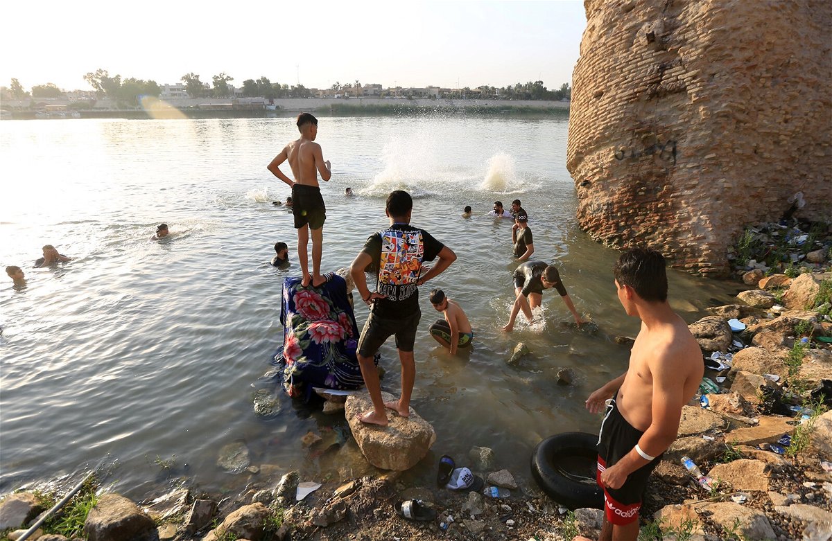 <i>Murtadha Al Sudani/Anadolu Agency/Getty Images</i><br/>People cool off at the Tigris River during hot weather in Baghdad