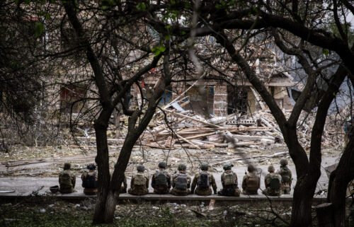 Ukrainian soldiers sit at the shelling scene of a destroyed school in Kramatorsk. Amnesty International said it "deeply regrets the distress and anger" caused by a report the group published on the Ukrainian military's fighting tactics