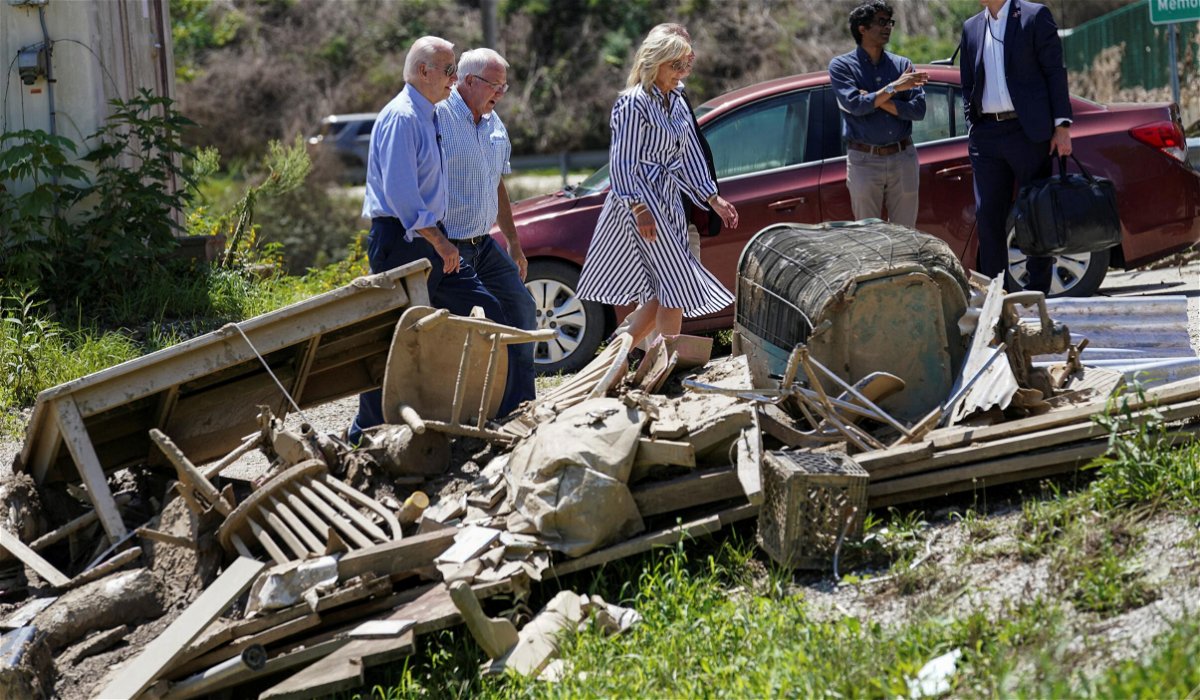 <i>Kevin Lamarque/Reuters</i><br/>U.S. President Joe Biden and first lady Jill Biden walk past debris while viewing flood damage and response efforts in Lost Creek