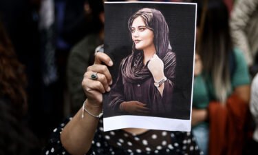 A protester holds a portrait of Mahsa Amini during a demonstration in her support in front of the Iranian embassy in Brussels