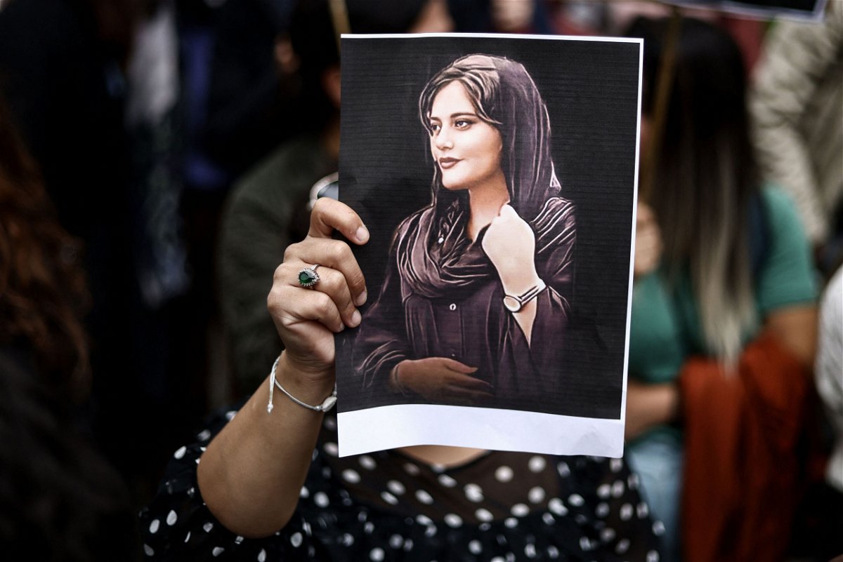 <i>Kenzo Tribouillard/AFP/Getty Images</i><br/>A protester holds a portrait of Mahsa Amini during a demonstration in her support in front of the Iranian embassy in Brussels