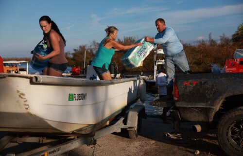 People load supplies onto a boat in Matlacha