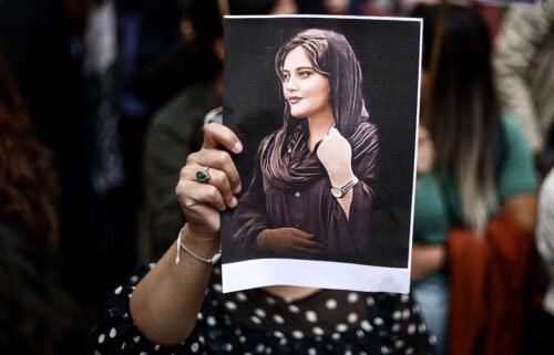 A protester holds a portrait of Mahsa Amini during a demonstration in her support in front of the Iranian embassy in Brussels on September 23.