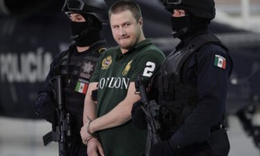 Edgar "La Barbie" Valdez Villareal is escorted by Mexican federal police during a news conference at the federal police center in Mexico City in August 2010. According to the Federal Bureau of Prisons