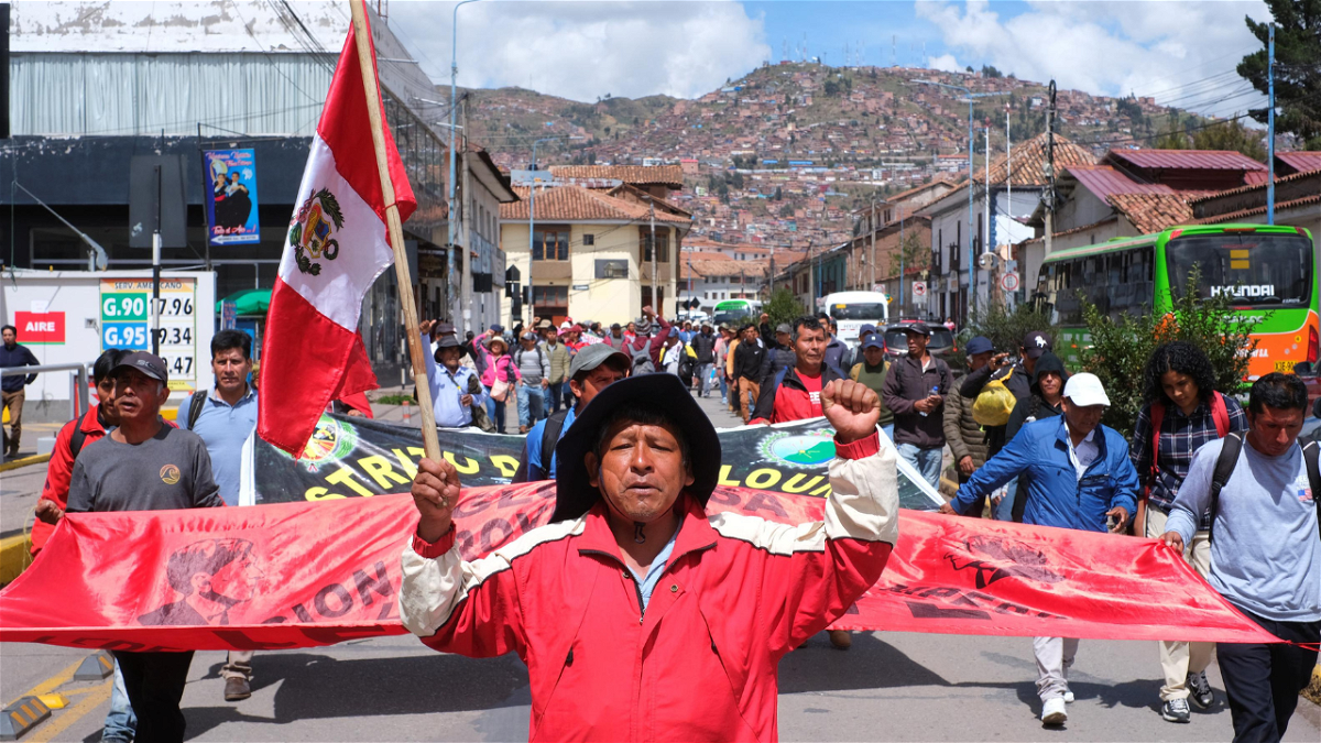 A man holds a Peruvian flag as he takes part on Wednesday in a demonstration in Cusco, Peru, before heading to Lima, to gather with protesters from around the country for the 'capture of Lima' march.