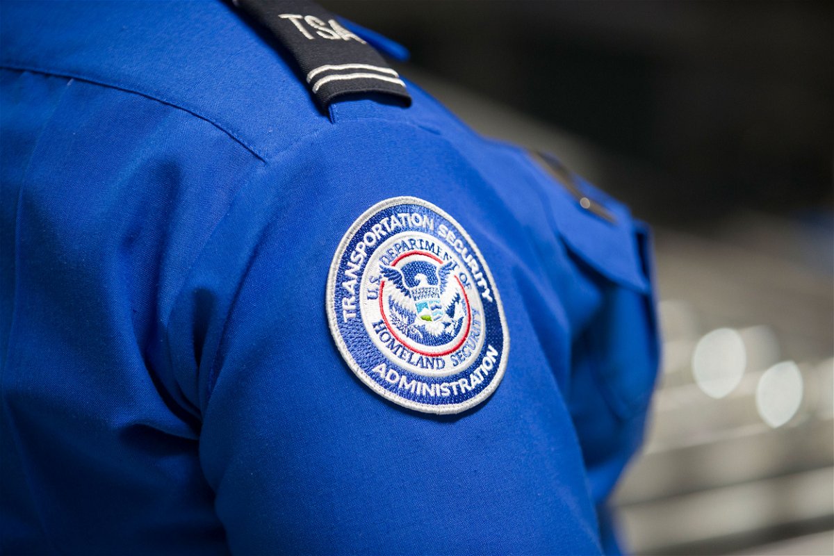 MIAMI, FLORIDA - MAY 21: A Transportation Security Administration (TSA) agent's patch is seen as she helps travelers place their bags through the 3-D scanner at the Miami International Airport on May 21, 2019 in Miami, Florida. TSA has begun using the new 3-D computed tomography (CT) scanner in a checkpoint lane to detect explosives and other prohibited items that may be inside carry-on bags.  (Photo by Joe Raedle/Getty Images)