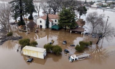This aerial view shows a flooded home partially underwater in Gilroy