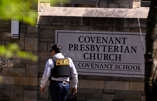 A police officer walks by an entrance to The Covenant School after a shooting in Nashville on March 27.