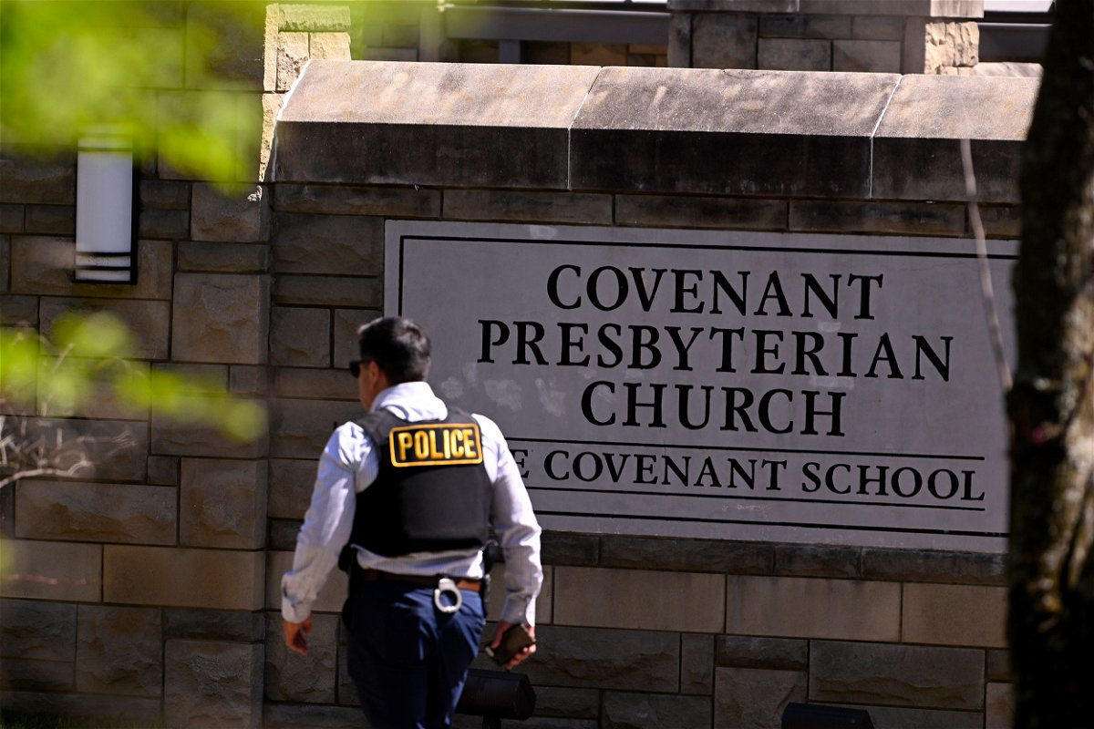 <i>John Amis/AP</i><br/>A police officer walks by an entrance to The Covenant School after a shooting in Nashville on March 27.