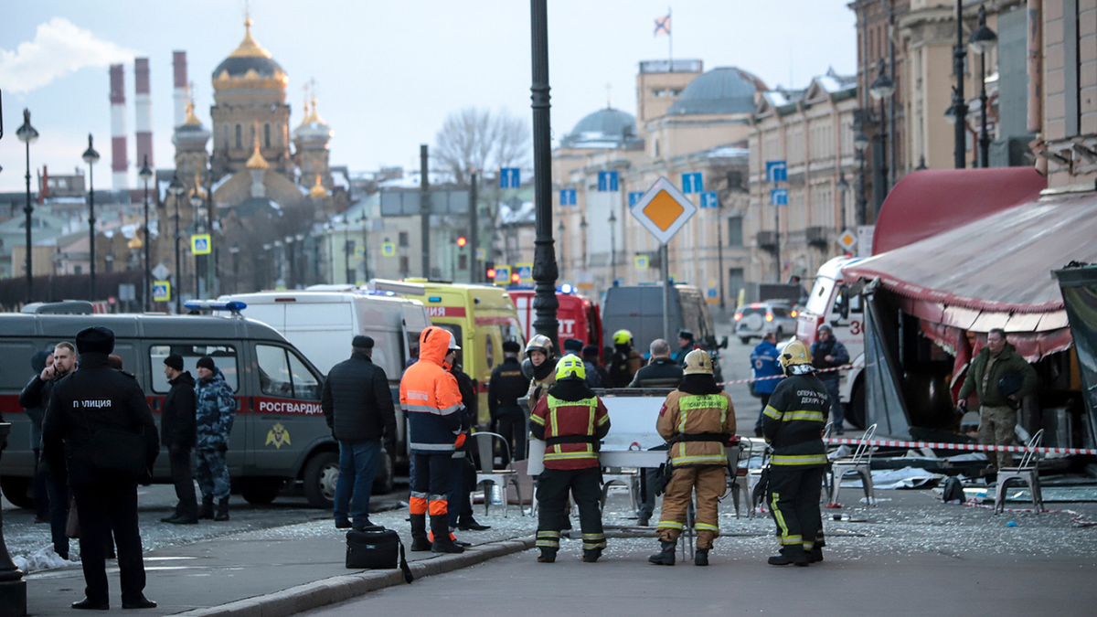 Emergency service workers stand at the site of the blast at the St. Petersburg cafe on Sunday. Russian authorities have, on Monday, detained a 26-year-old anti-war protester in connection with the explosion.
