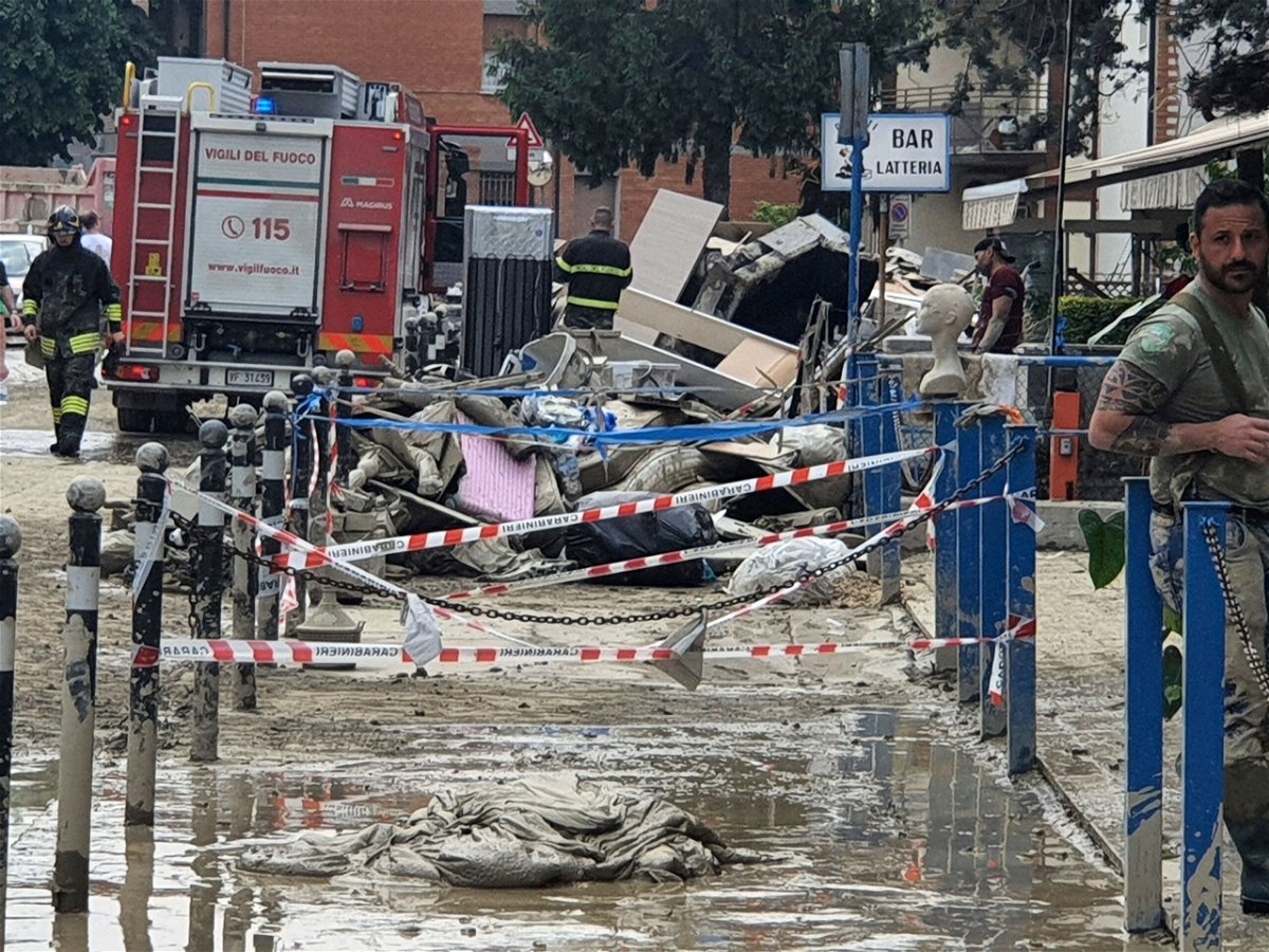 <i>Francesco Amendola/LaPresse/AP</i><br/>Firefighters help clear debris and mud from a street in Forli