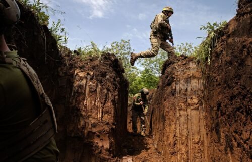 A Ukrainian Army soldier jumps over a gap in a defensive trench outside Kostyanynivka