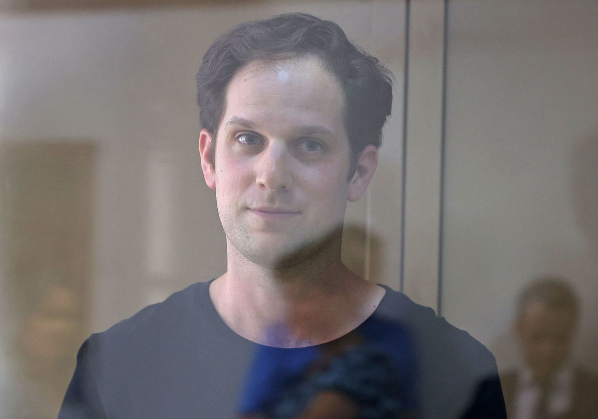 Evan Gershkovich stands in a glass enclosure for defendants at his court hearing in Moscow.
