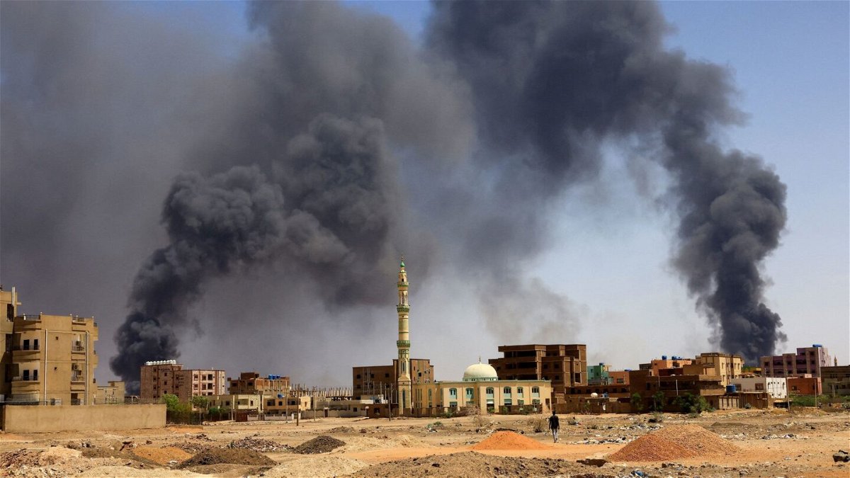 <i>Mohamed Nureldin Abdallah/Reuters</i><br/>A man walks while smoke rises above buildings after aerial bombardment