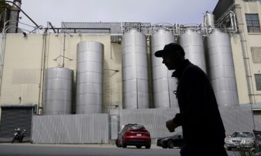 A person walks across the street from Anchor Brewing Co. in San Francisco.