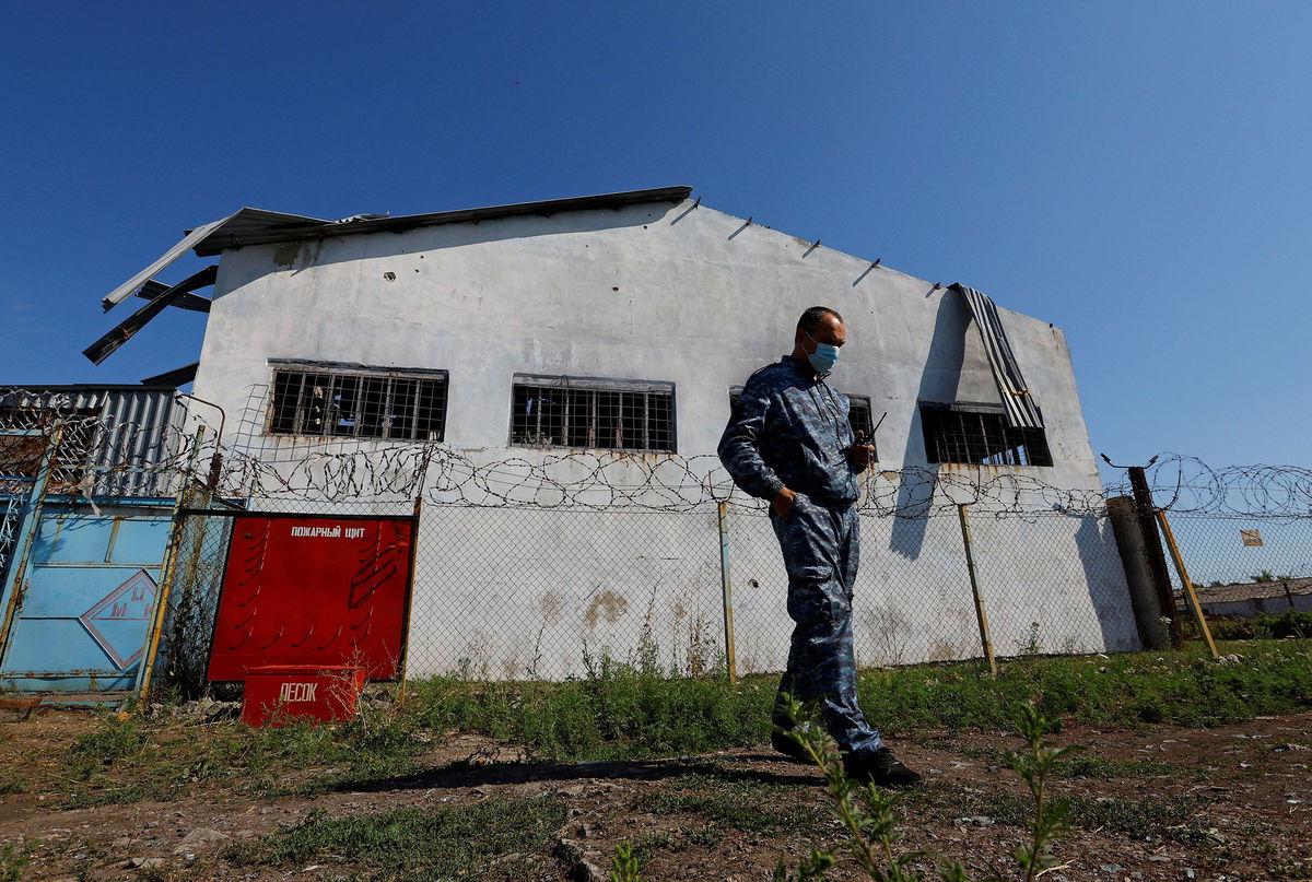 <i>Alexander Ermochenko/Reuters</i><br/>A security guard stands in front of the building in the settlement of Olenivka in the Donetsk Region