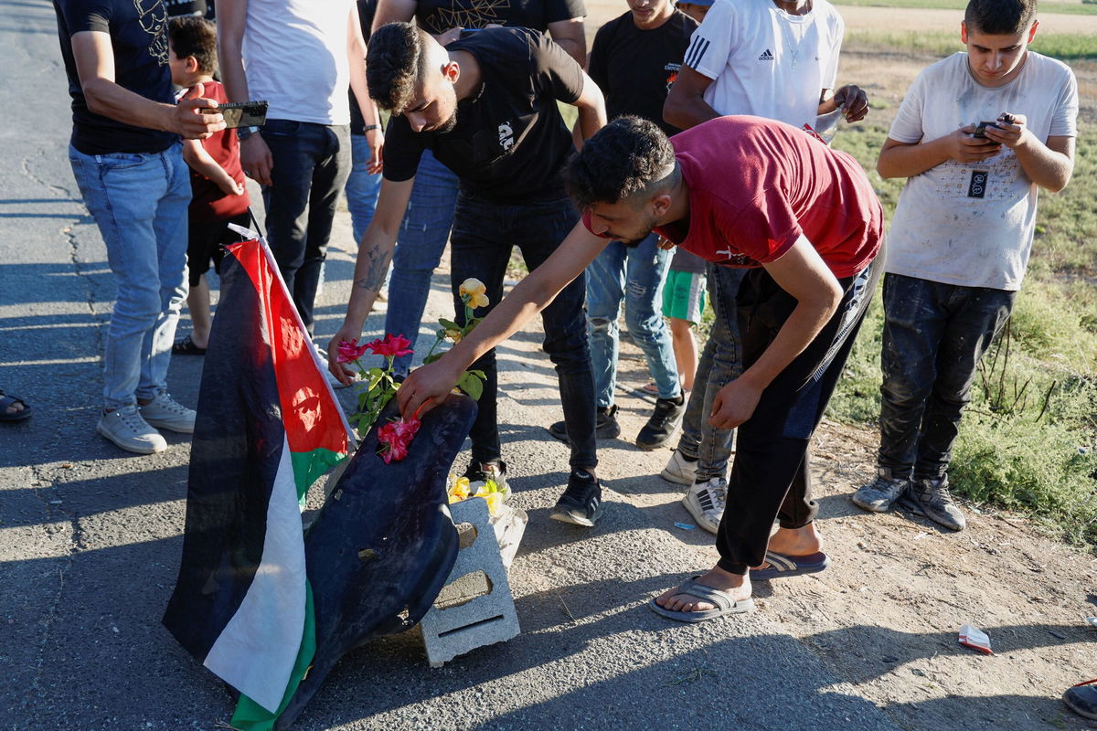 <i>Raneen Sawafta/Reuters</i><br/>Palestinians gather at the scene where Israeli forces targeted a Palestinian car