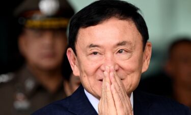 Former Thai prime minister Thaksin Shinawatra greets supporters as he arrives at Don Mueang International Airport on August 22 in Bangkok